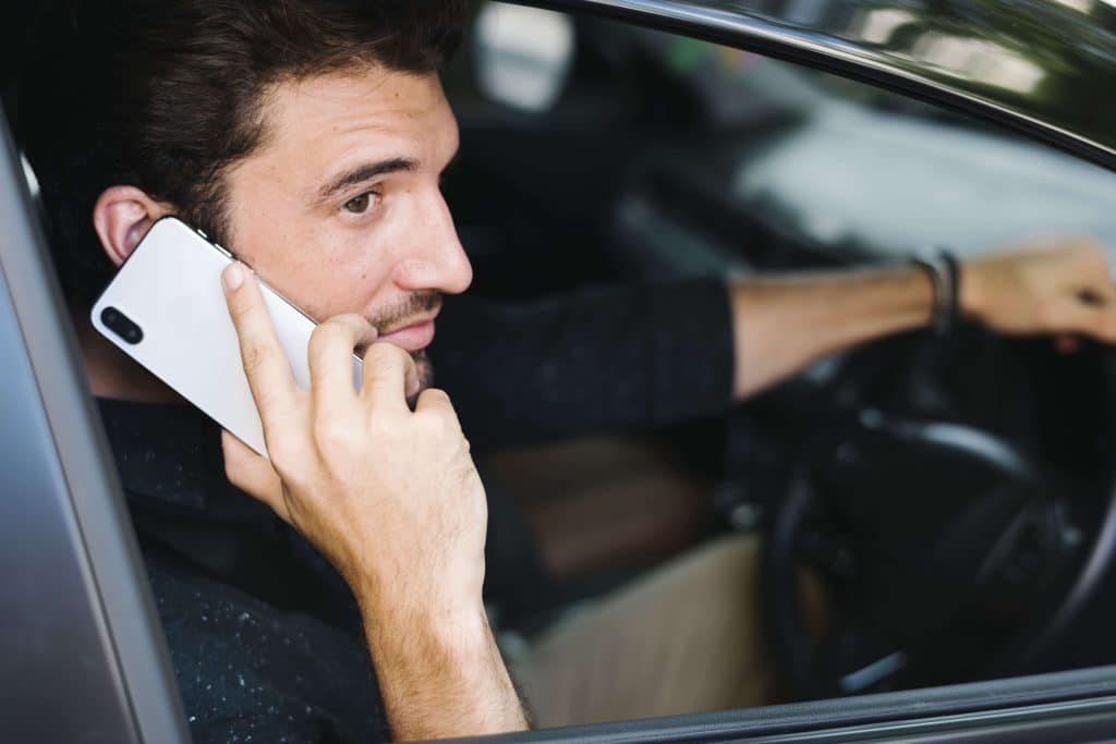 Homem usando celular dentro de carro