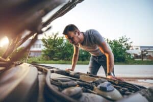 pane elétrica: pessoa analisando carro com capô levantado