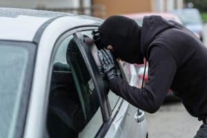 Ladrão olhando dentro de carro estacionado