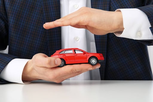 Homem segurando mini carro nas mãos