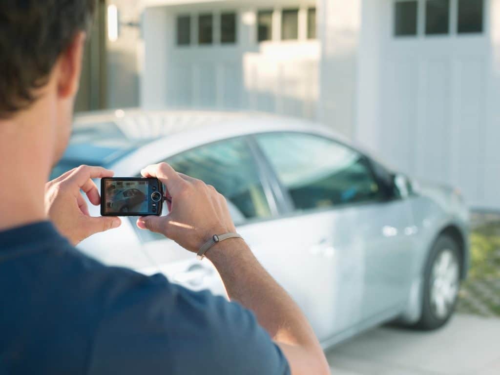 Pessoa tirando foto de um carro