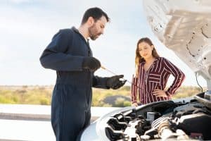 Homem verificando o óleo do motor de um carro
