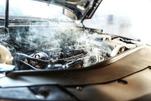 Capô do carro aberto saindo fumaça