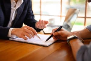 Duas pessoas analisando um contrato de seguro de carro