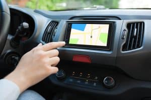 Mão interagindo com multimídia do carro