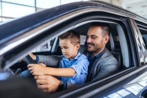 Pai com o filho no colo dentro do carro