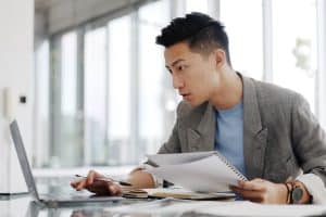 Homem utilizando notebook para fazer cobertura de seguro